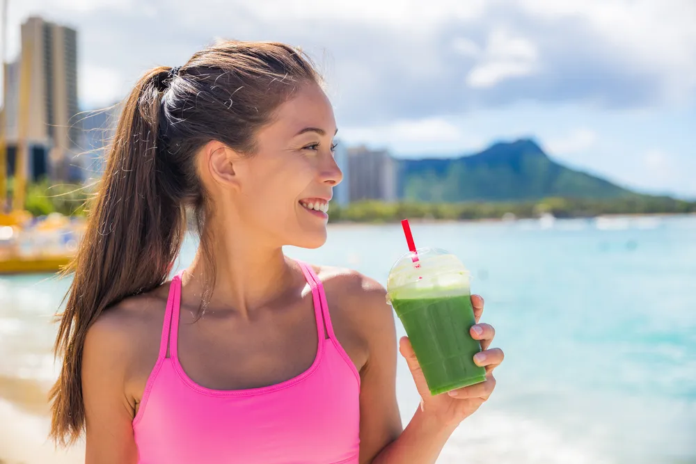 vrouw-bikini-drinkt-smoothie-op-strand